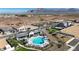 Community pool with mountain views, ample seating, umbrellas, and a playground area in a desert community at 17247 W Daley Ln, Surprise, AZ 85387