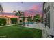 Expansive backyard featuring lush green turf, pool, and outdoor dining area for entertaining at 18001 N 44Th Way, Phoenix, AZ 85032
