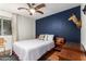 This bedroom offers hardwood floors, a ceiling fan, and a unique accent wall at 18001 N 44Th Way, Phoenix, AZ 85032