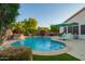 Sparkling pool with a rock waterfall, lush greenery, and lounge chairs for a relaxing backyard experience at 18001 N 44Th Way, Phoenix, AZ 85032
