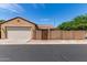 Exterior view of the home showcasing the garage, driveway, and gated front yard with well-maintained desert landscaping at 1843 S Sunnyvale Ave, Gilbert, AZ 85295