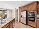 Well-equipped kitchen with stainless steel appliances, granite countertops, and rich wood cabinetry at 1843 S Sunnyvale Ave, Gilbert, AZ 85295