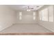Large, carpeted living room with ceiling fan and plentiful natural light from two windows at 1843 S Sunnyvale Ave, Gilbert, AZ 85295