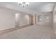 Open-concept living room with beige carpet, tile flooring, and natural light at 1843 S Sunnyvale Ave, Gilbert, AZ 85295