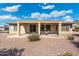 A covered backyard patio with a table and chairs overlooking the low maintenance landscaped yard at 19005 N Diamante Dr, Surprise, AZ 85387