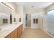 Bathroom featuring double sinks, a walk-in shower, and access to a closet at 19005 N Diamante Dr, Surprise, AZ 85387