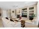 Open living room showcasing a fireplace, custom built-ins, tile flooring and ample seating at 19005 N Diamante Dr, Surprise, AZ 85387