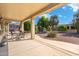 Covered patio with table and chairs, offering an outdoor living space with views of a landscaped backyard at 19005 N Diamante Dr, Surprise, AZ 85387