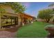 Expansive backyard featuring a lush lawn, covered patio, and desert landscaping at 20627 W Grandview Dr, Buckeye, AZ 85396
