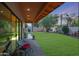 Expansive backyard featuring a lush lawn, covered patio, and mature trees at 20627 W Grandview Dr, Buckeye, AZ 85396