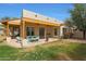 Covered patio featuring a cozy seating area with view of the landscaped backyard at 20627 W Grandview Dr, Buckeye, AZ 85396