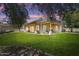 Large backyard with a covered patio, lush green lawn and mature trees at 20627 W Grandview Dr, Buckeye, AZ 85396
