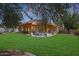 Expansive backyard featuring a lush lawn, covered patio with seating area, and desert landscaping at 20627 W Grandview Dr, Buckeye, AZ 85396