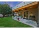 Covered patio with ceiling fan and seating overlooking spacious landscaped backyard at 20627 W Grandview Dr, Buckeye, AZ 85396