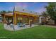 Covered patio with ceiling fan and seating overlooking spacious landscaped backyard at 20627 W Grandview Dr, Buckeye, AZ 85396