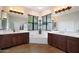 Bathroom featuring dual sinks, a corner tub, and bright windows with backyard view at 20627 W Grandview Dr, Buckeye, AZ 85396