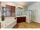 Well-lit bathroom featuring a soaking tub, shower and cherry wood vanity at 20627 W Grandview Dr, Buckeye, AZ 85396