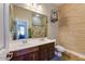 Well-lit bathroom with dual sinks, tile floors, and decorative birdcage at 20627 W Grandview Dr, Buckeye, AZ 85396