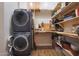 Laundry room features stacked washer and dryer with custom natural wood shelving and countertops at 20627 W Grandview Dr, Buckeye, AZ 85396