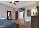 An elegant primary bedroom features wood flooring, walk-in closet, ceiling fan and bathroom at 20627 W Grandview Dr, Buckeye, AZ 85396