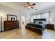 Cozy bedroom with ample natural light, wood-look floors, and a comfortable king-sized bed at 20627 W Grandview Dr, Buckeye, AZ 85396