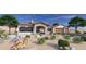Charming single-story home features a stone facade, two-car garage, and desert landscaping with vibrant cacti at 21347 W Jojoba Ct, Buckeye, AZ 85396