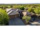 Aerial view of desert home and golf course with a large driveway and a two-car garage at 23014 N 52Nd St, Phoenix, AZ 85054