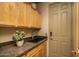Functional laundry room featuring ample cabinet space, granite countertop, and a convenient utility sink at 23014 N 52Nd St, Phoenix, AZ 85054