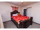 Bedroom with a floral-patterned bedspread, a ceiling fan, and a dark wooden bed frame, providing cozy comfort at 2305 E Southern Ave, Phoenix, AZ 85040