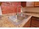 A close-up of kitchen featuring stainless steel double sink with granite counters and wooden cabinetry for storage at 2305 E Southern Ave, Phoenix, AZ 85040