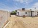 Backyard view of a white single-story house featuring a brick-paved parking area and block fence at 2628 W Marshall Ave, Phoenix, AZ 85017