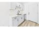 Kitchen featuring modern white cabinets, quartz countertops, stainless appliances, and stylish flooring at 2628 W Marshall Ave, Phoenix, AZ 85017