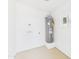 Water heater in utility room with painted floor and access for washer and dryer hookups at 2628 W Marshall Ave, Phoenix, AZ 85017
