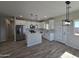Well-lit kitchen featuring an island, white cabinets, stainless steel appliances, and wood-look tile flooring at 26308 W Camino Del Sol --, Casa Grande, AZ 85193