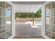 View of a spacious backyard and sparkling swimming pool seen through open french doors at 2640 E Mallory St, Mesa, AZ 85213