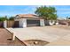 View of the home's side exterior with a spacious driveway and gray garage door at 2640 E Mallory St, Mesa, AZ 85213