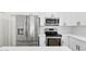 Modern kitchen features stainless steel appliances and white cabinets with black hardware and subway tile backsplash at 2640 E Mallory St, Mesa, AZ 85213