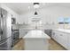 Bright kitchen features stainless steel appliances, white cabinets, and an island with a breakfast bar at 2640 E Mallory St, Mesa, AZ 85213