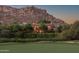Stunning home exterior overlooking lush greenery, water, and mountain backdrop at 27050 N 103Rd St, Scottsdale, AZ 85262