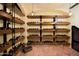 A gorgeous wine cellar with terracotta tile flooring and lots of display shelves to house a large collection of bottles at 27050 N 103Rd St, Scottsdale, AZ 85262