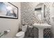 Stylish powder room featuring unique mosaic tile accent wall, pedestal sink and modern fixtures at 30857 N 128Th Dr, Peoria, AZ 85383