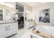 Elegant bathroom showcasing double vanities, soaking tub, crystal chandelier, and access to bedroom at 30857 N 128Th Dr, Peoria, AZ 85383