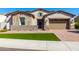 Attractive single-story home with stone accents, a brick driveway and gate, and tidy landscaping at 30857 N 128Th Dr, Peoria, AZ 85383