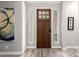 Elegant foyer with a dark wood door, sidelights, wood flooring, and stylish artwork at 30857 N 128Th Dr, Peoria, AZ 85383