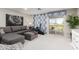 Comfortable living room with a gray sectional sofa, stylish decor, and sliding glass doors to the outdoors at 30857 N 128Th Dr, Peoria, AZ 85383