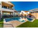 Backyard pool features a baja step surrounded by artificial turf and patio with second-story covered deck at 30857 N 128Th Dr, Peoria, AZ 85383