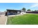 A well-maintained backyard features a covered patio area, a dining set, and a lush green lawn at 325 W San Angelo St, Gilbert, AZ 85233