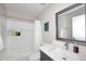 Bright bathroom features a shower-tub combo, modern vanity, and decorative mirror at 325 W San Angelo St, Gilbert, AZ 85233