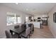 Bright dining area with a dark wood table and open access to a modern white kitchen with stainless appliances at 325 W San Angelo St, Gilbert, AZ 85233
