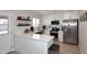 Modern kitchen with white cabinetry, marble countertops, and stainless-steel appliances overlooking a dining area at 325 W San Angelo St, Gilbert, AZ 85233